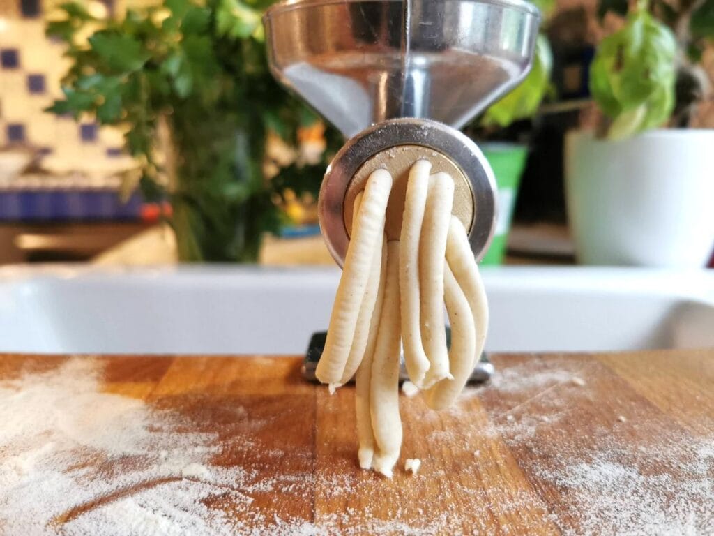 casarecce being extruded through the dough press (torchio)