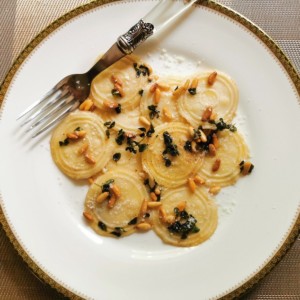 Homemade corzetti pasta with marjoram and pine nuts