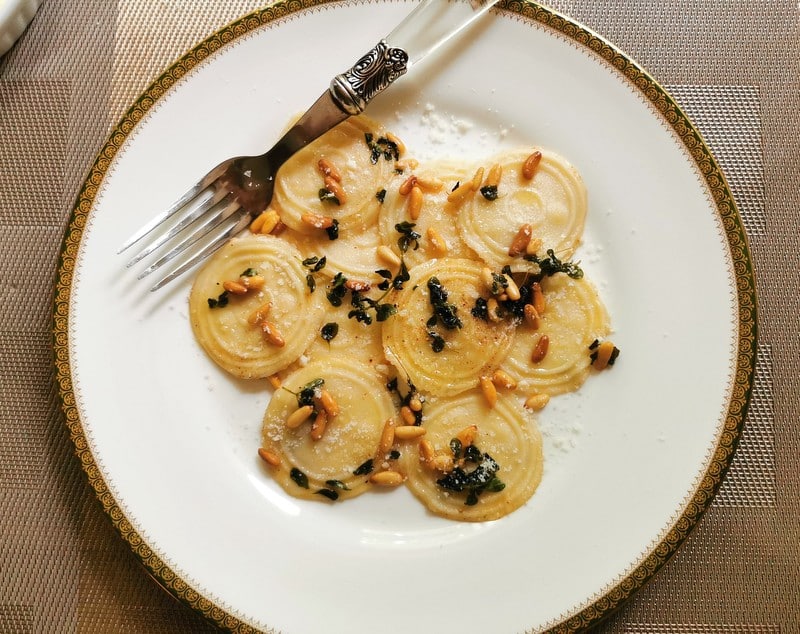 Homemade corzetti pasta with marjoram and pine nuts.