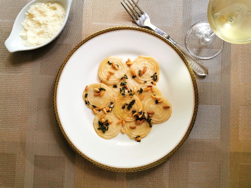 Homemade corzetti pasta with marjoram and pine nuts.