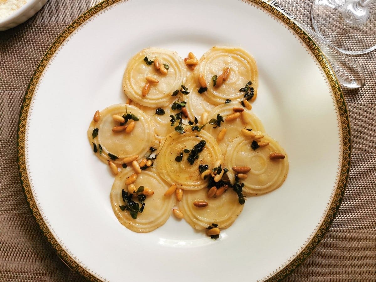 Homemade corzetti pasta with marjoram and ine nuts.