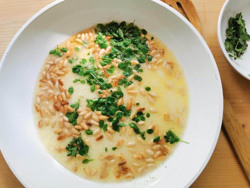 fresh marjoram added to melted butter and toasted pine nuts