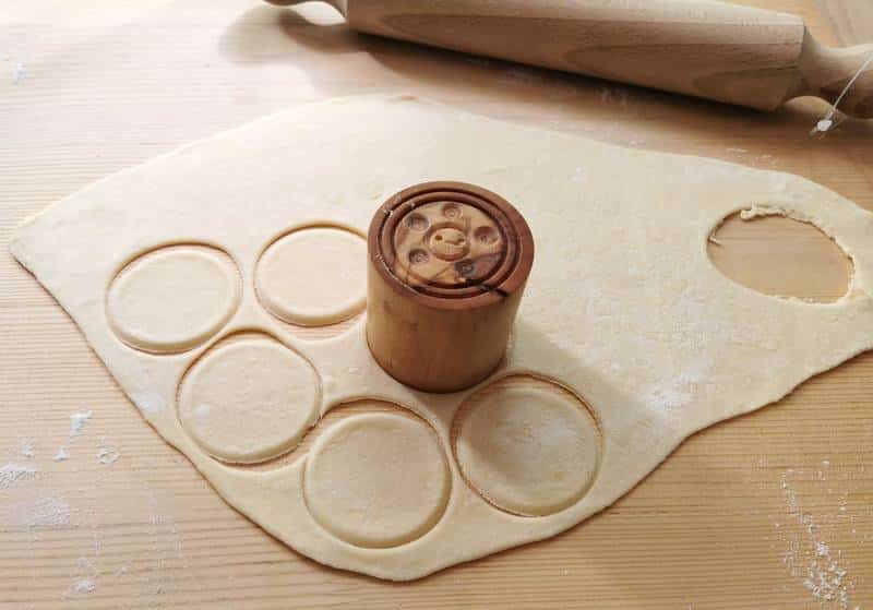 pasta discs cut out of dough using corzetti stamp