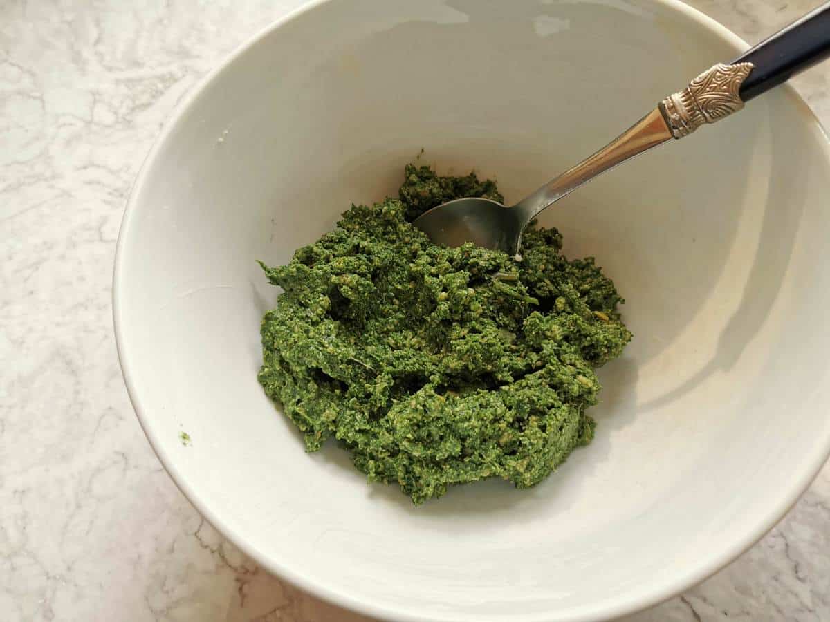 Meat and spinach filling for fagottini and agnolotti in white bowl.
