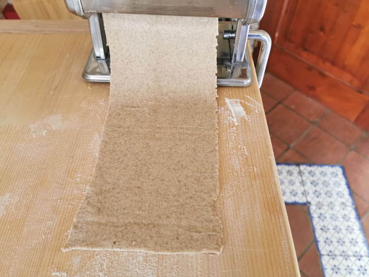 Sheet of rye flour dough in manual pasta machine.