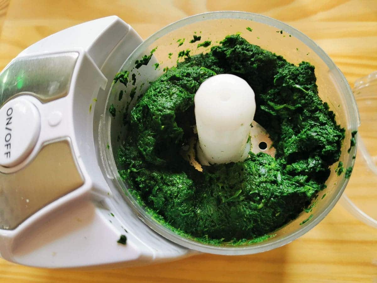 Puréed cooked spinach in food processor.