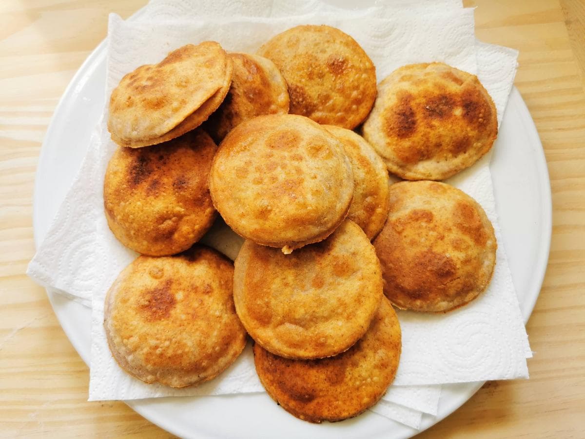 Ready fried ravioli on white plate covered with kitchen paper.