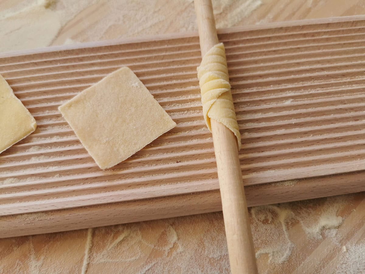Square of pasta rolled around wooden dowel to create garganelli.