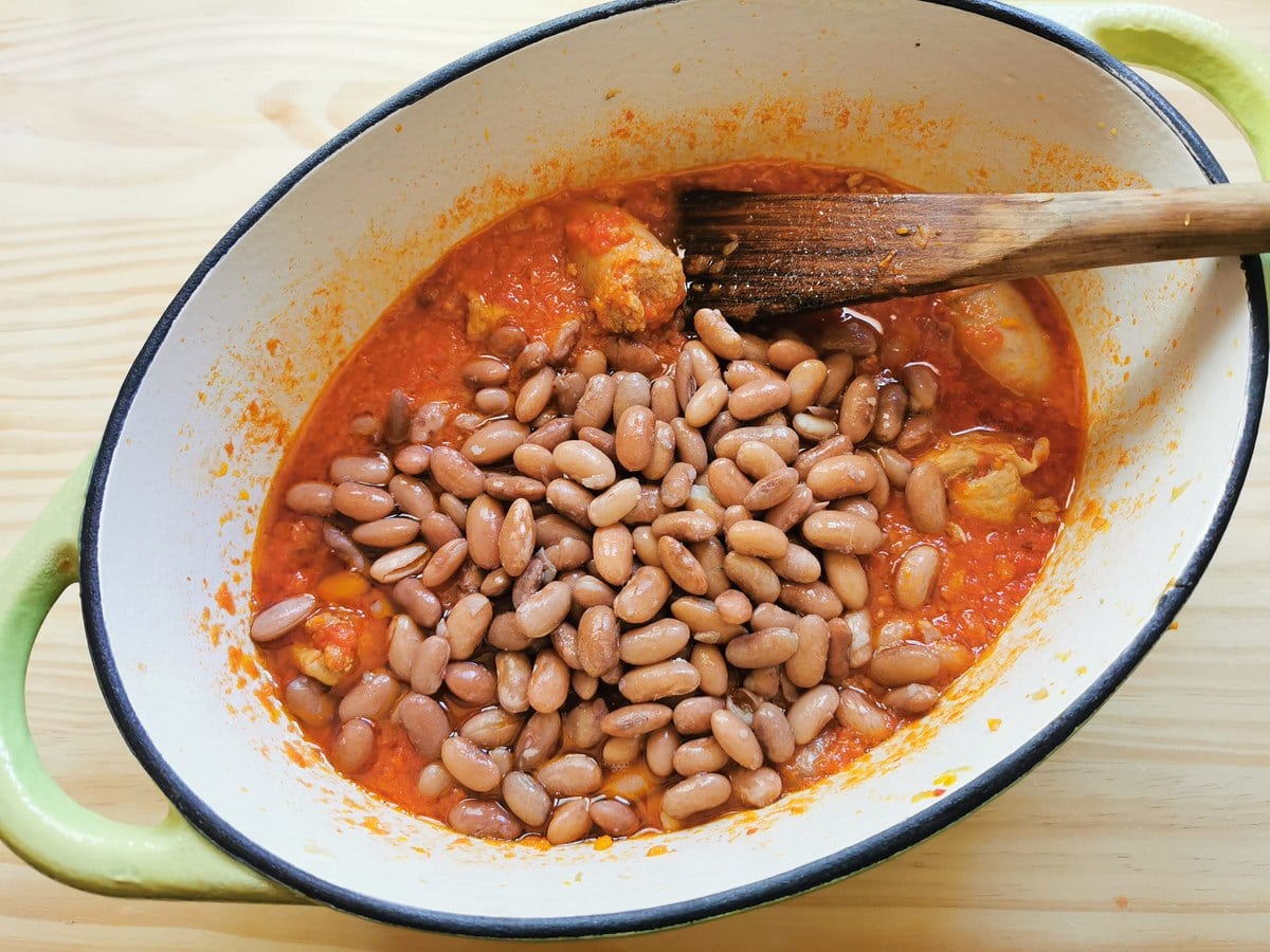 Cooked borlotti beans in Ducth oven with sausage ragu.