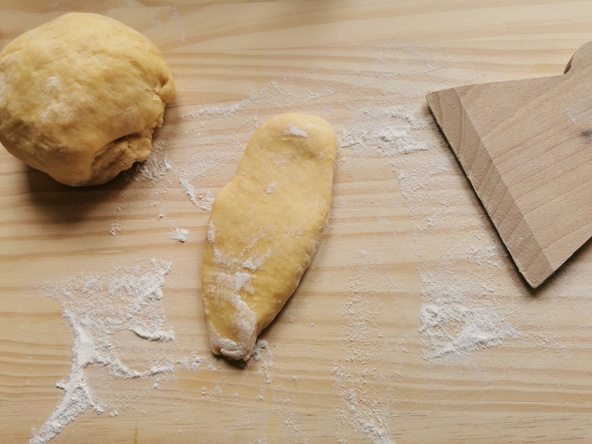 One piece of ravioli dough cut off from the dough ball and flattened.