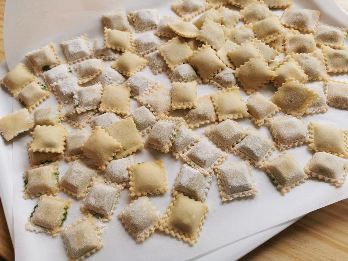 Ready fresh meat ravioli (agnolotti) on tray.