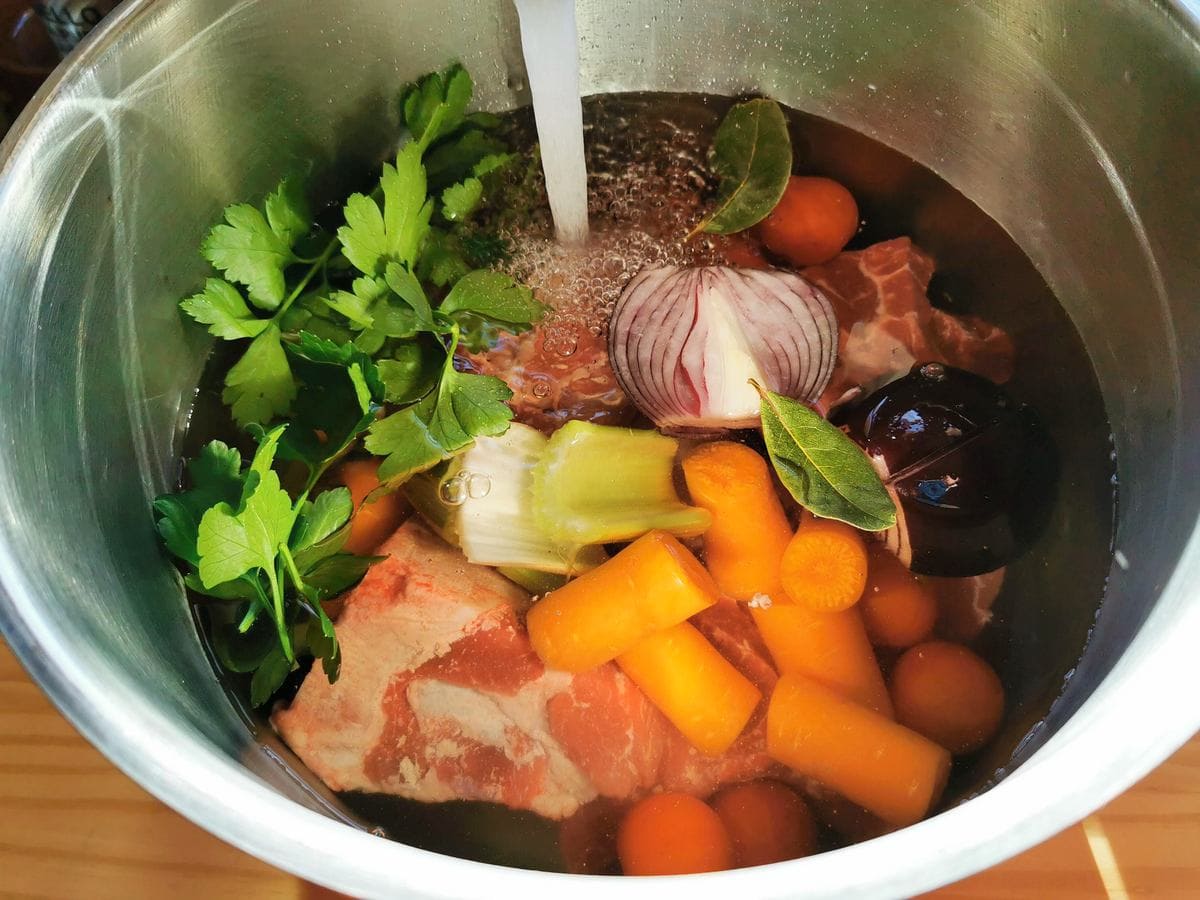 Beef broth ingredients in large pot filled with water.