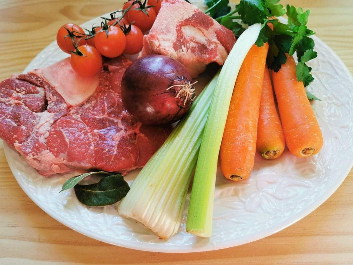 Ingredients for beef broth on oval white plate.