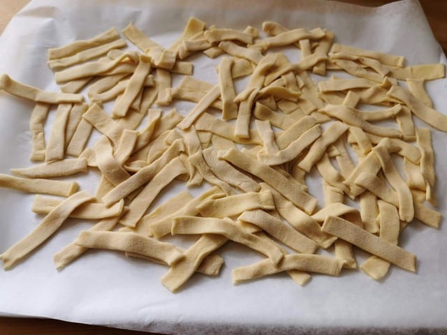 homemade sagne pasta on floured tray