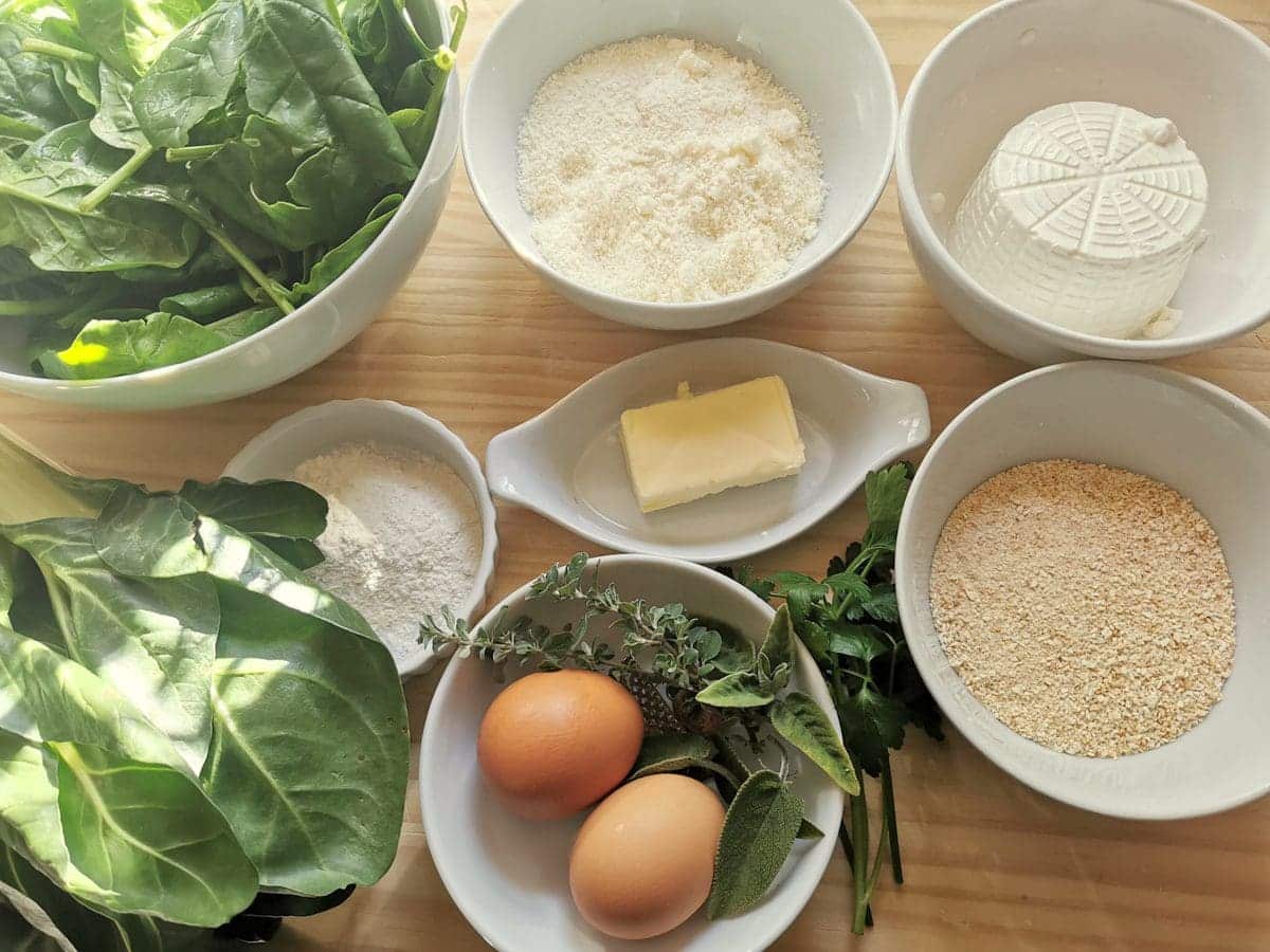 Ingredients for spinach gnocchi with ricotta (rabatòn) on wood work surface.