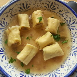 Homemade stuffed mezze maniche in broth