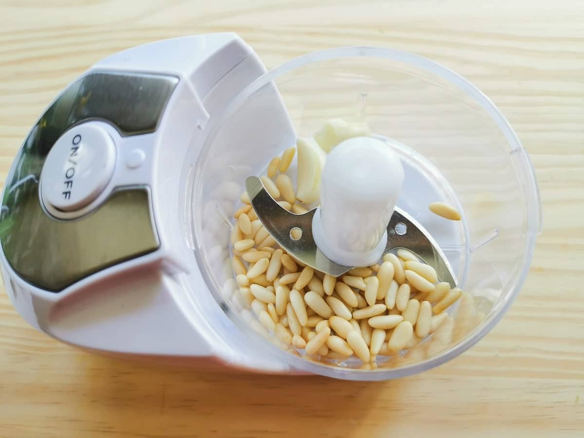 garlic cloves and pine nuts in food processor