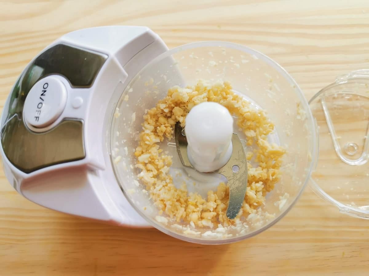 small pieces of pine nuts and garlic in food processor