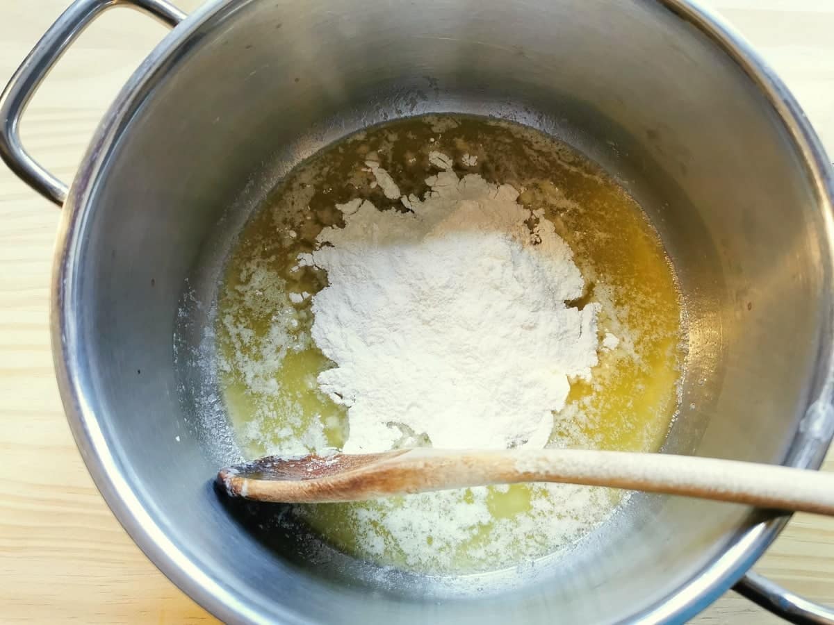 Melted butter in saucepan with flour on top.