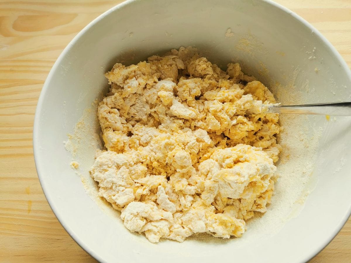 Eggs and flour mixed together in white bowl.