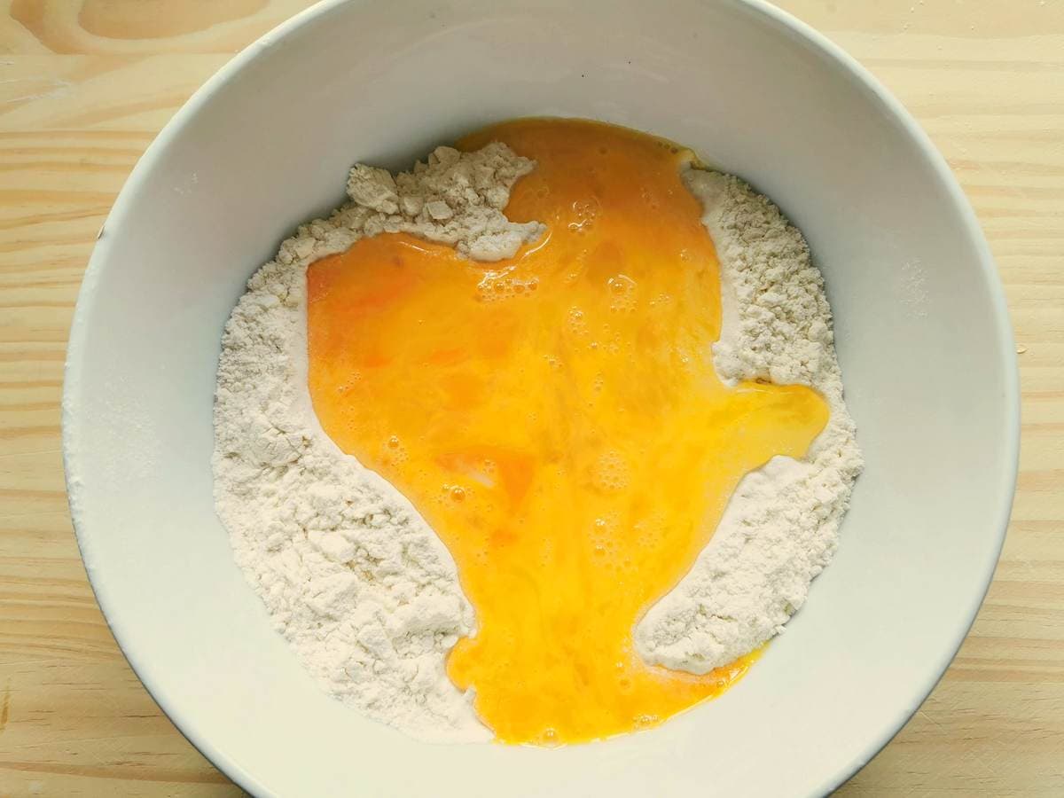 Flour and beaten eggs in white bowl.