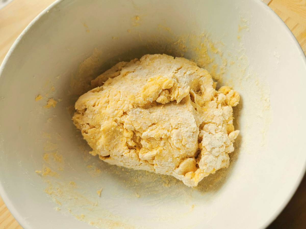 A ball of dough inside a white bowl.