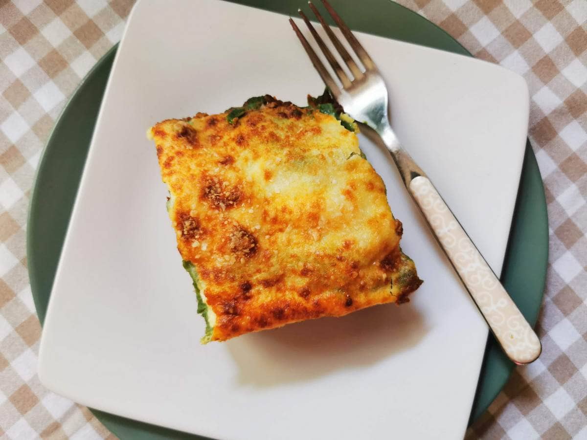 Portion of lasagne al forno with Bolognese on white plate.
