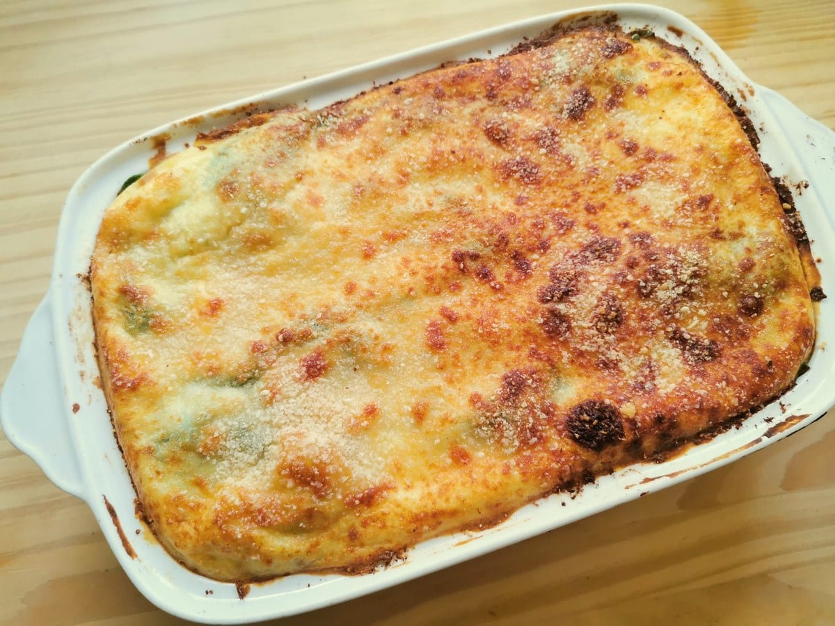 Ready baked lasagne al forno with Bolognese in white oven dish.