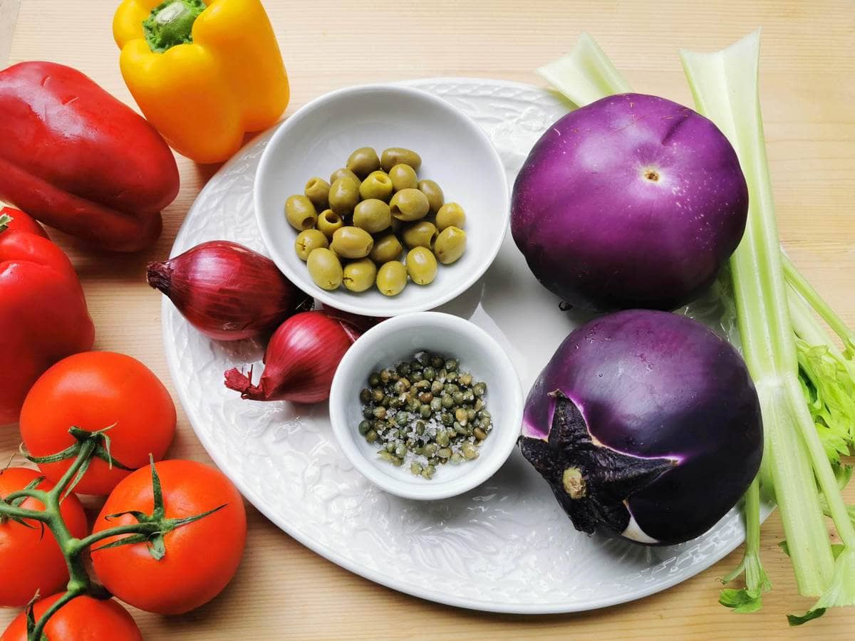 Ingredients for Sicilian caponata on white plate.