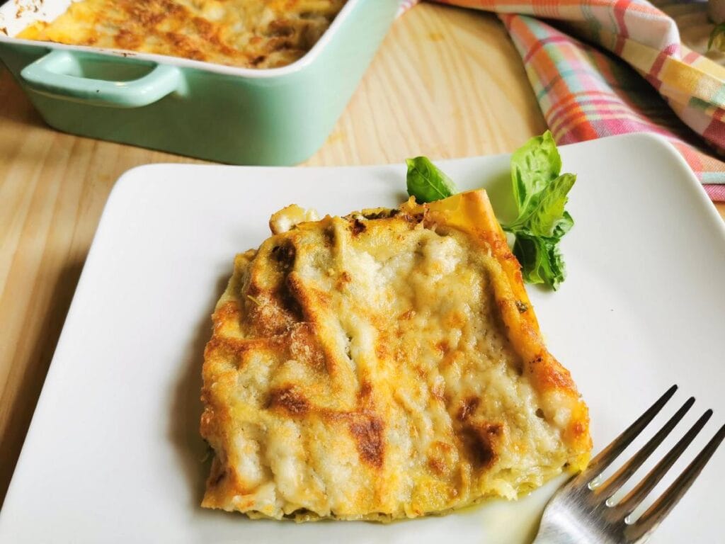 Pesto lasagne al forno on a plate with basil.