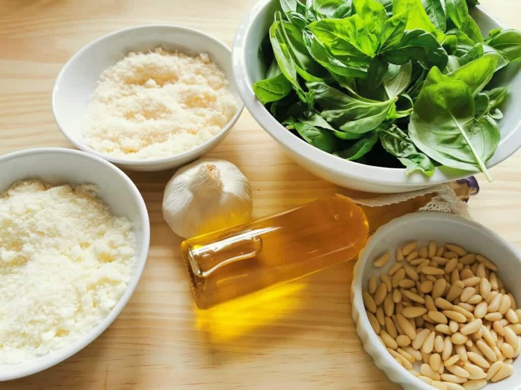 ingredients for homemade basil pesto on wooden board