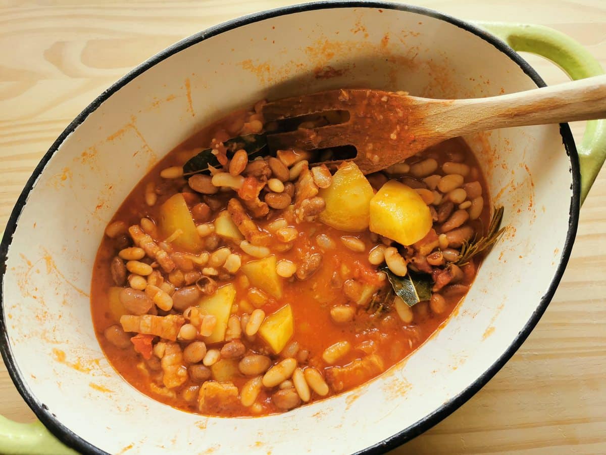 Beans added to soup ingredients in Dutch oven.