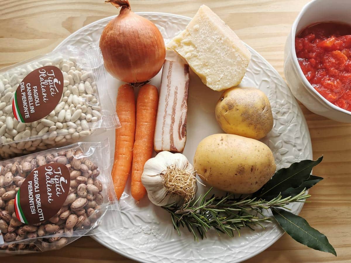 Ingredients for pasta fagioli on white plate.