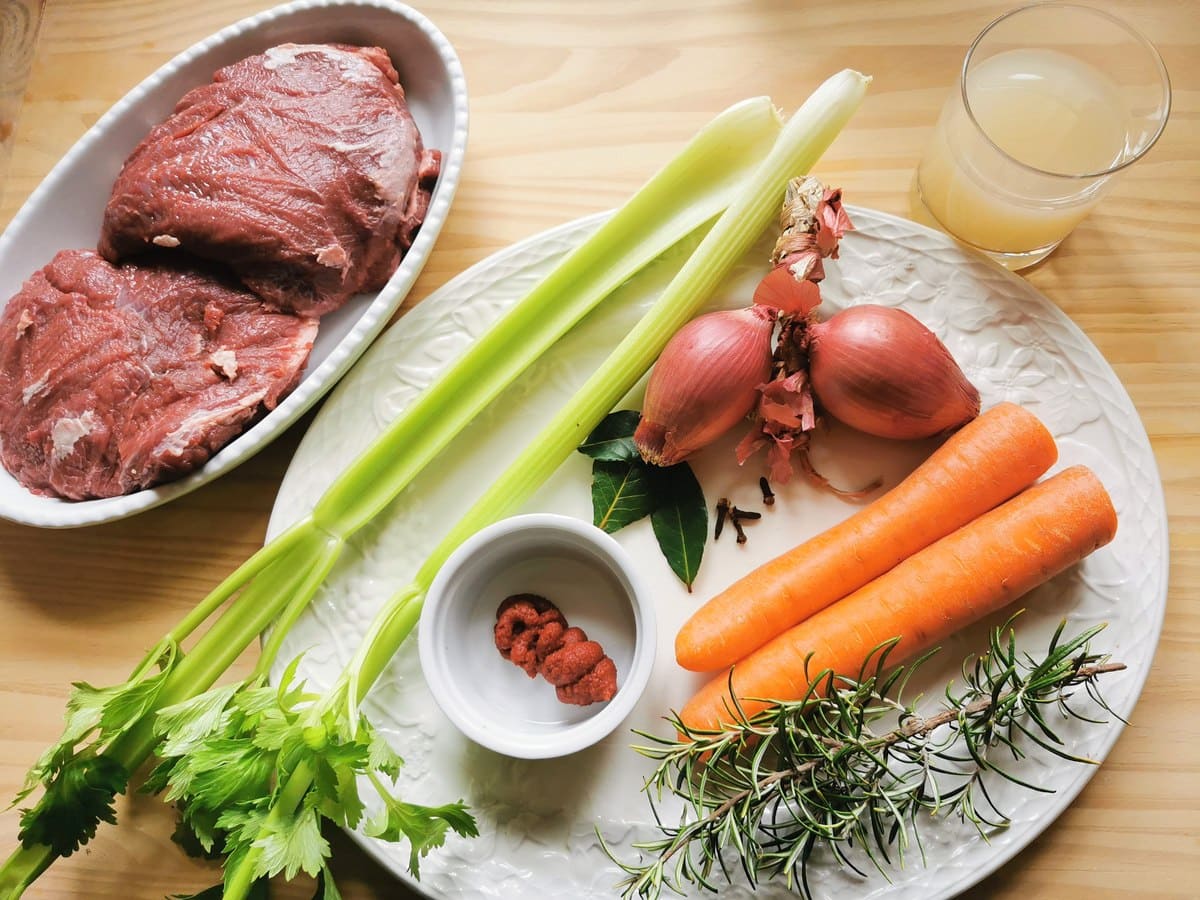 Ingredients for Italian beef cheek ragu on white plate.