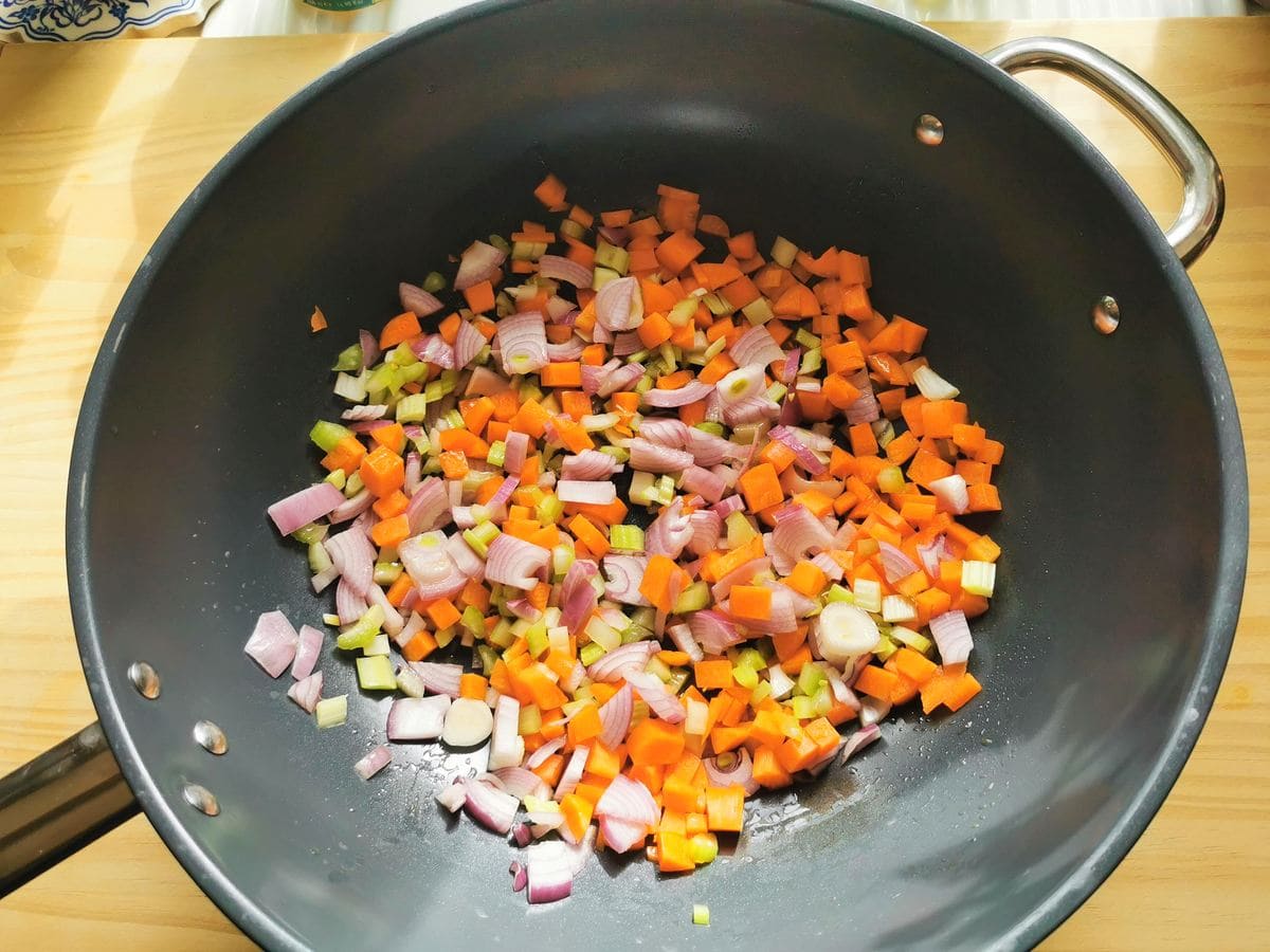 Diced onion, celery and carrot cooking in deep skillet.