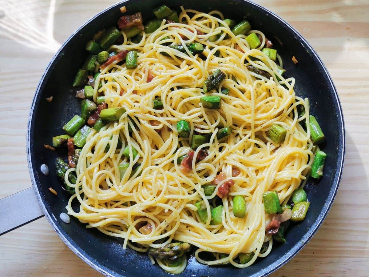 ready Italian carbonara with asparagus in skillet