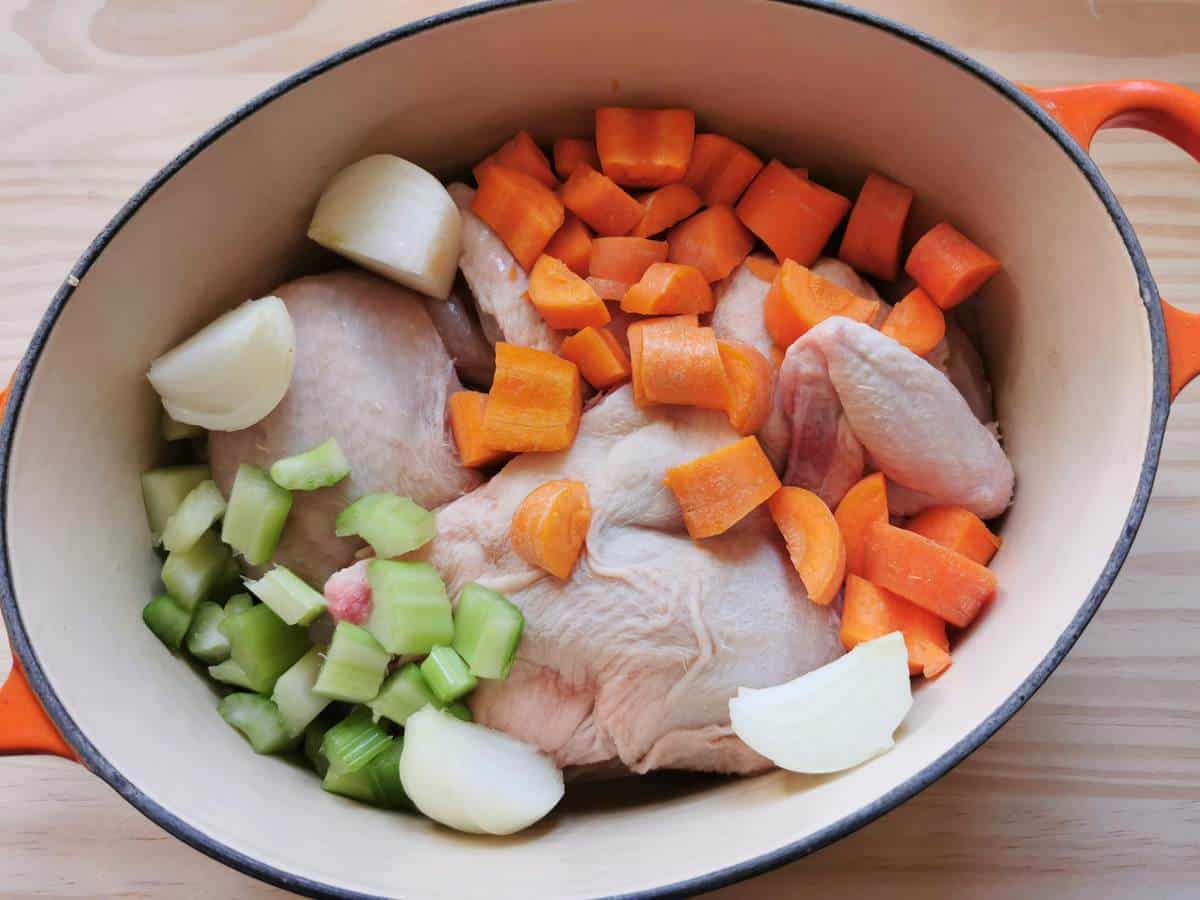 chicken pieces, carrots, celery and onion in Dutch oven ready to make broth