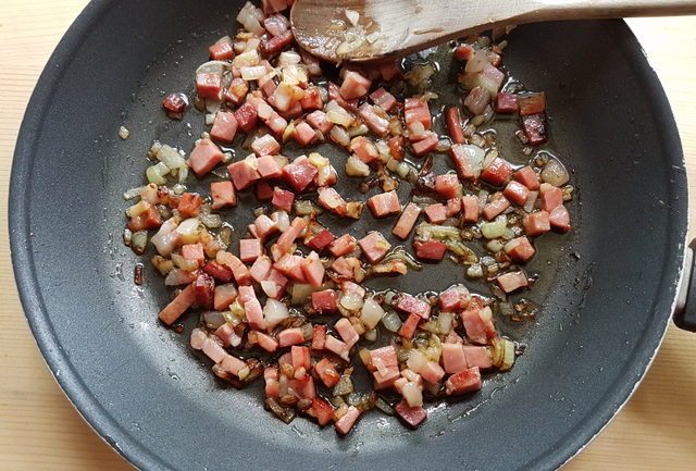 speck and onions cooking in skillet