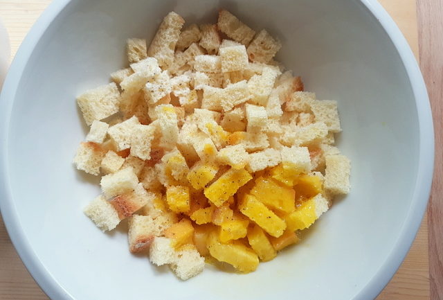 stale bread cubes in white bowl with beaten egg