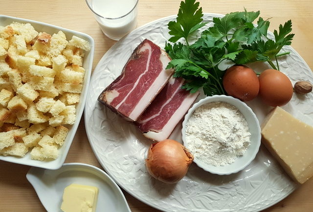 ingredients for canederli (Italian bread dumplings) on white plate