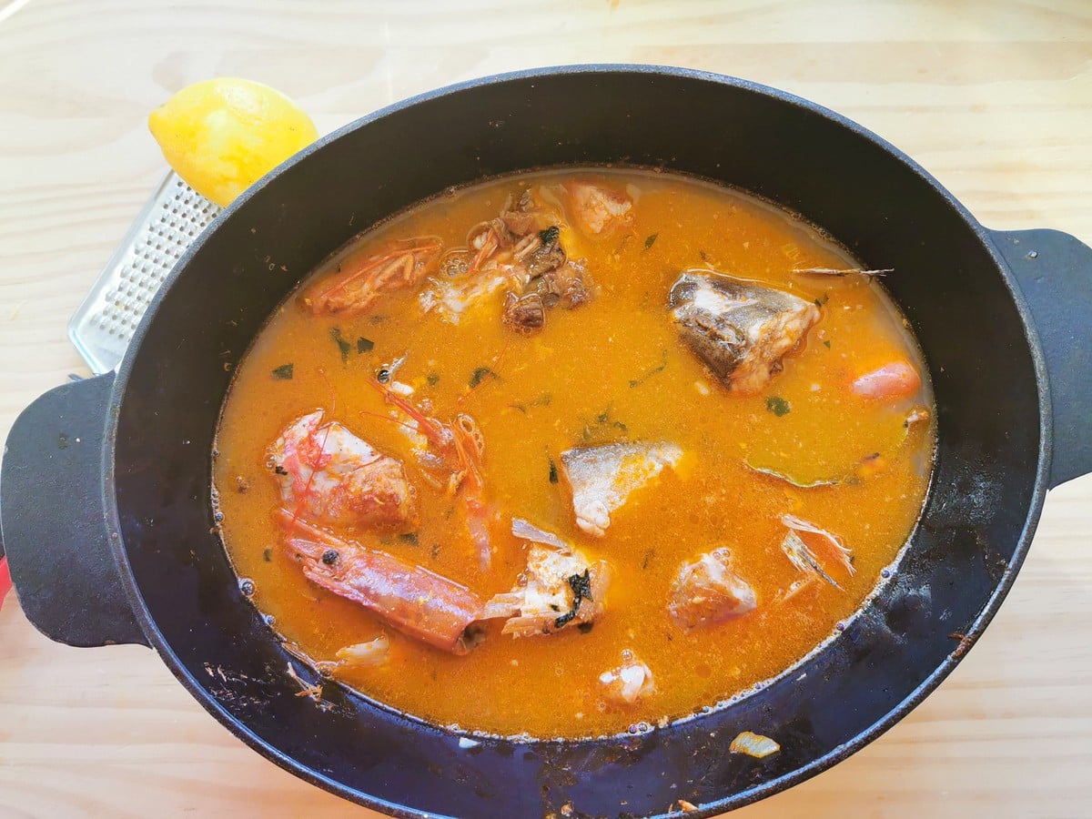 The vegetable broth in the Dutch oven with the fish.