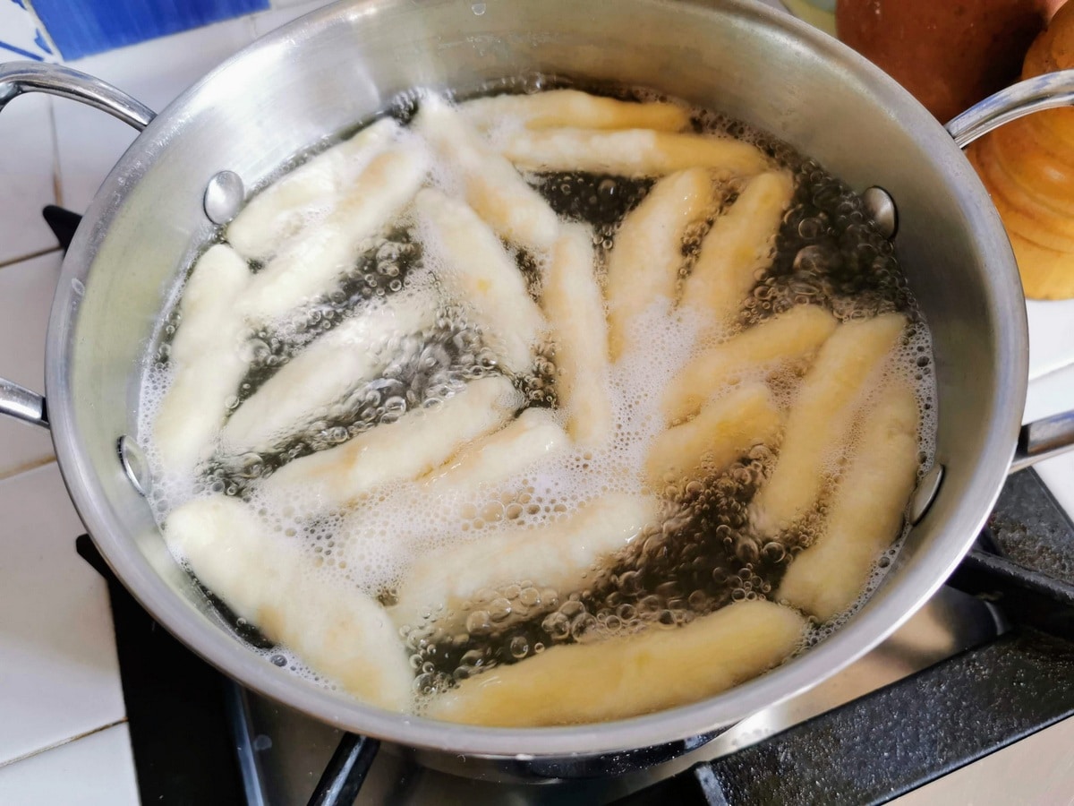 Italian potato gnocchi cooking in pot of boiling water.