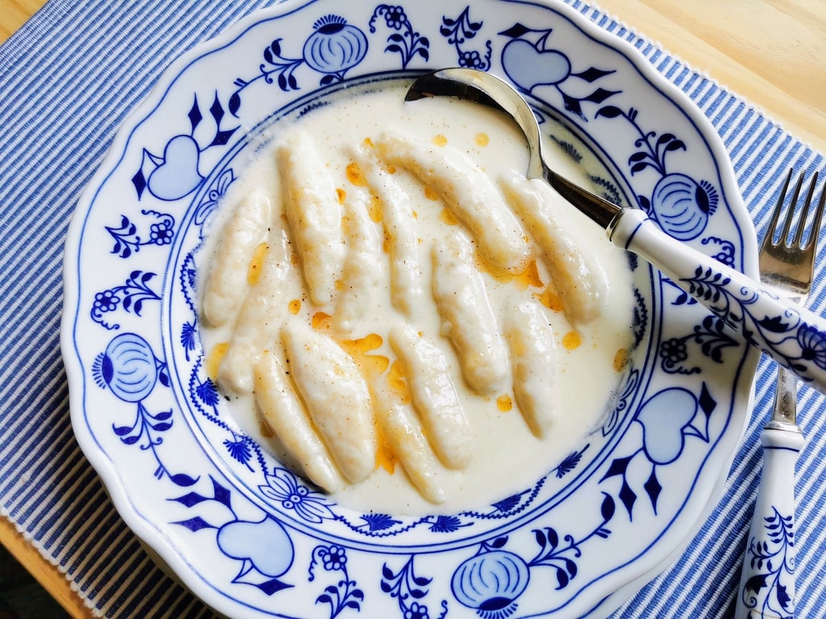 Potato gnocchi with a creamy cheese sauce in a bowl.