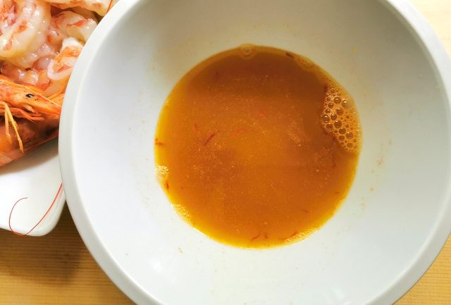 prawn broth with saffron in white bowl