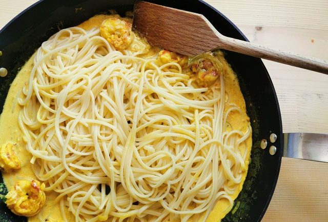 drained and cooked linguine in skillet with prawn saffron sauce