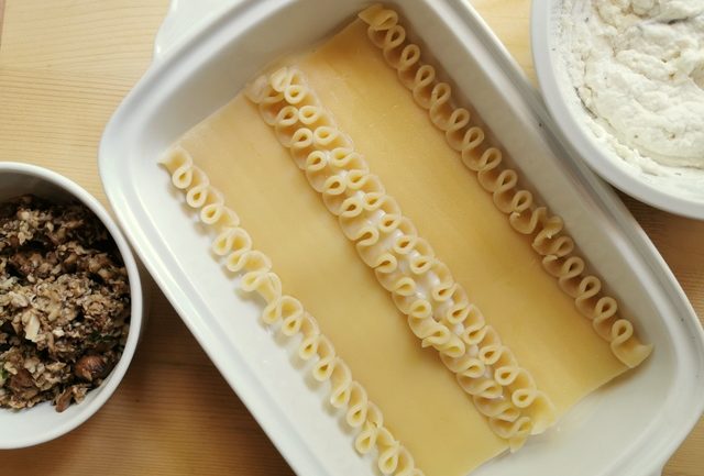 2 partly cooked lasagne in white rectangular oven dish.