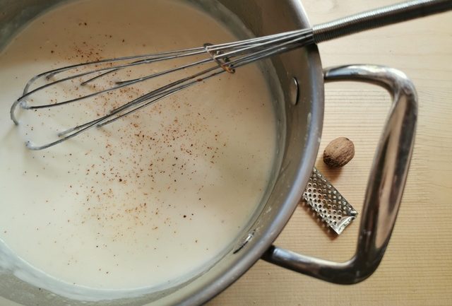 béchamel (white sauce) in saucepan with whisk