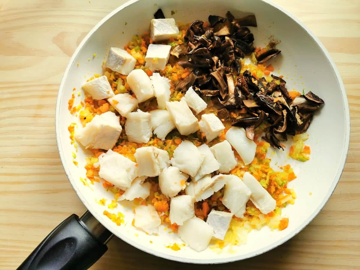 Salt cod chunks and drained porcini in frying pan with the soffritto.