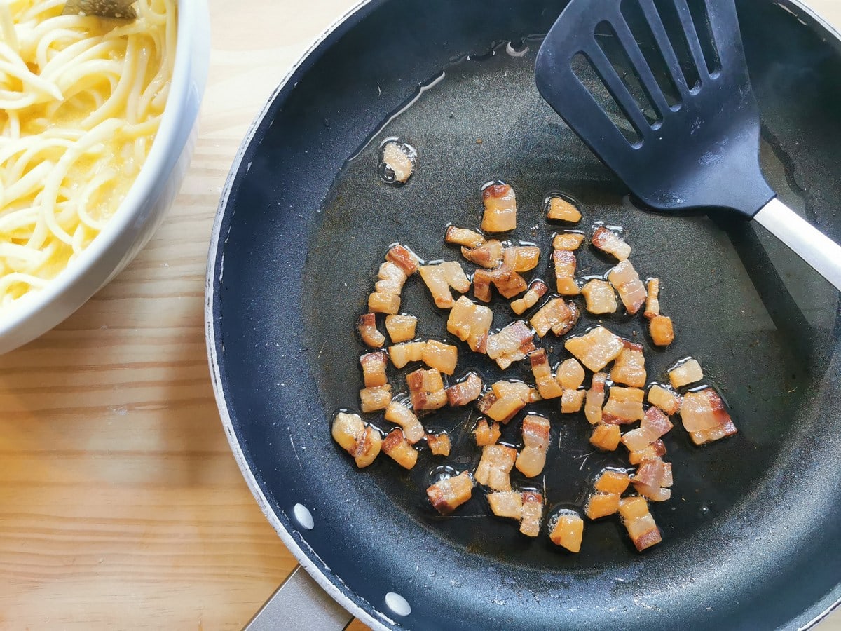 Browned guanciale cubes in skillet.