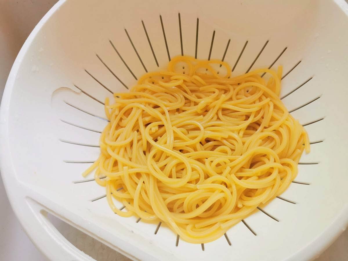 cooked and drained spaghetti in white colander